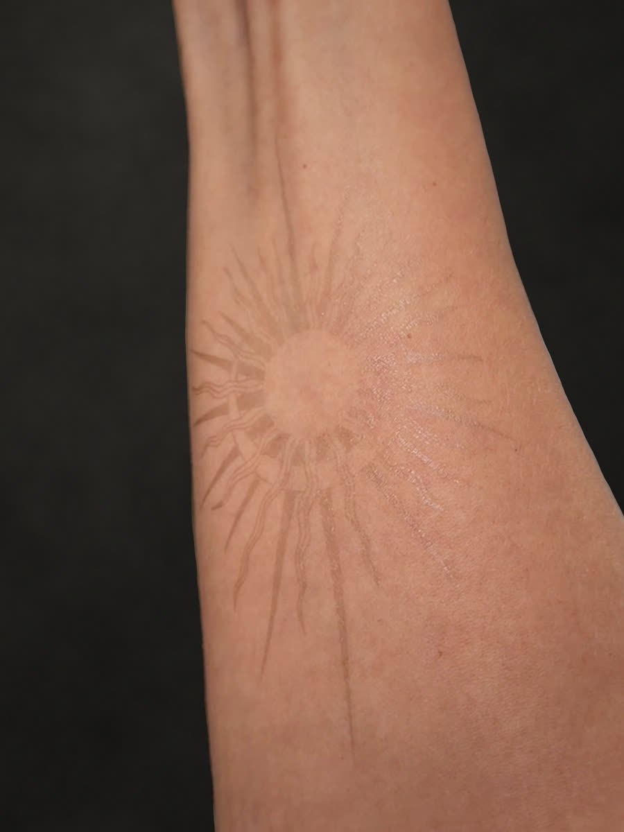 Right after applying: sun tattoo on the forearm, still light